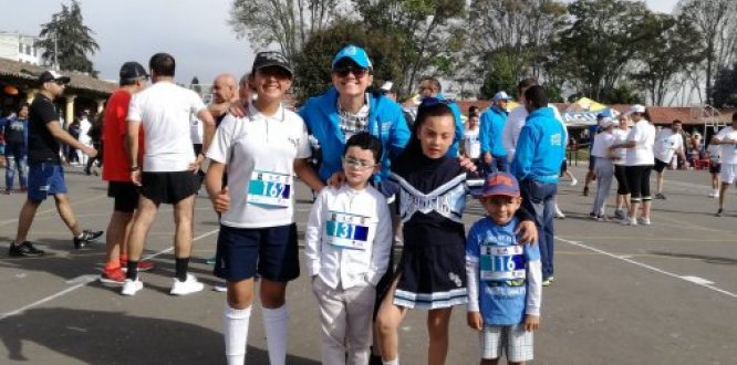 Foto de la Alcaldesa con niños, usando ropa deportiva.