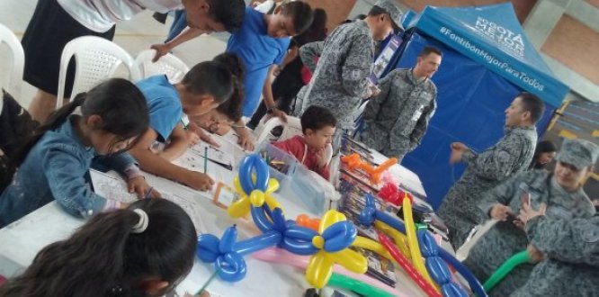Foto donde se aprecian niños y niñas jugando y personas de la Fuerza Aérea junto a ellos